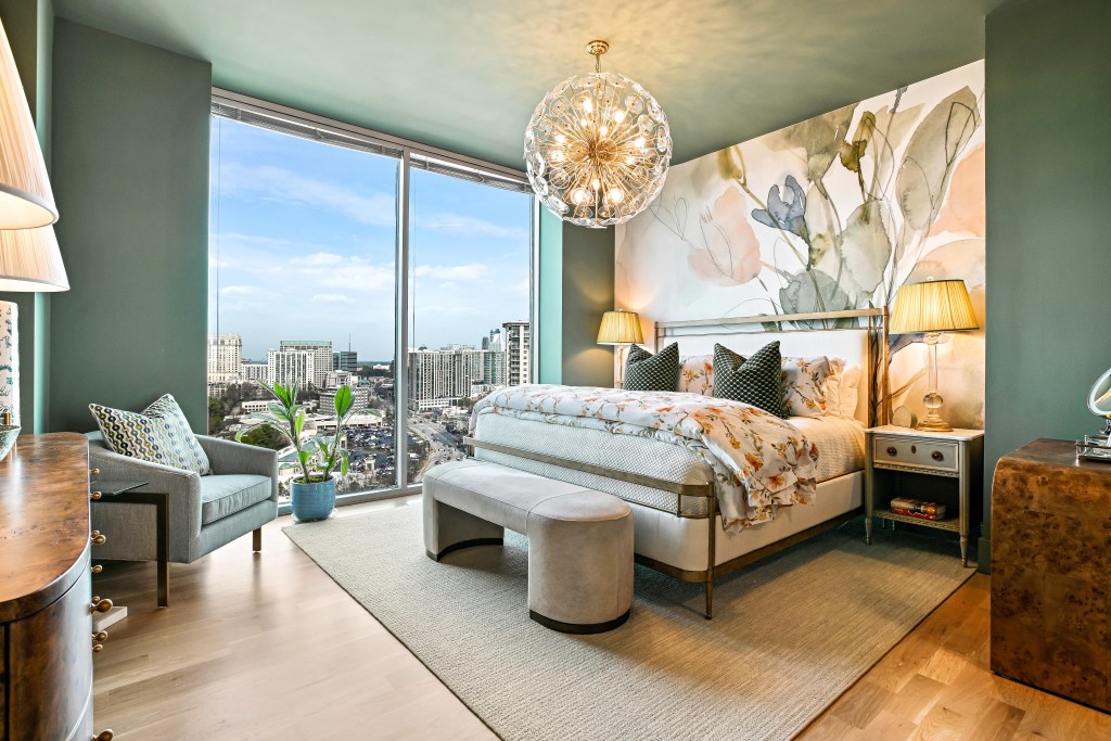 4-inch solid white oak floor in the primary bedroom of a Buckhead high-rise condominium, with a corner window and city view, installed and site-finished by Classy Flooring ATL.