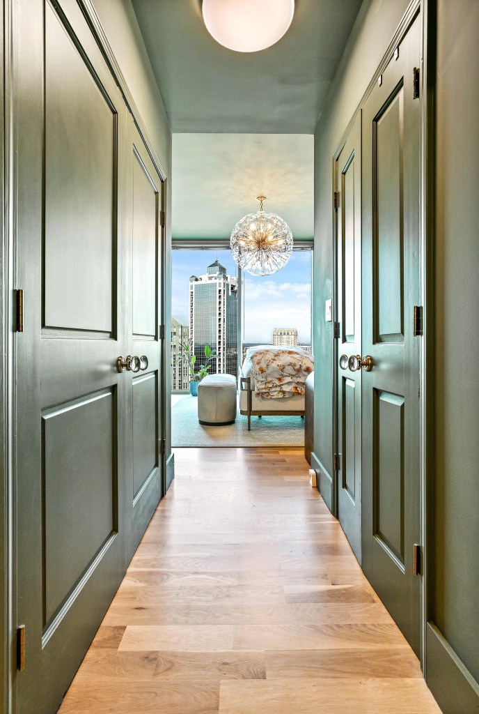 4-inch solid white oak floor running down the hallway of a Buckhead high-rise condominium toward the open living area, installed and site-finished by Classy Flooring ATL.