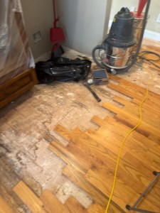 Installing replacement red oak boards during water-damage floor restoration in Atlanta