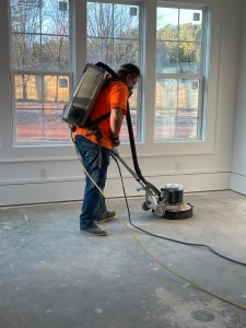 Concrete floor grinding before custom herringbone installation using prefinished engineered oak flooring in Atlanta
