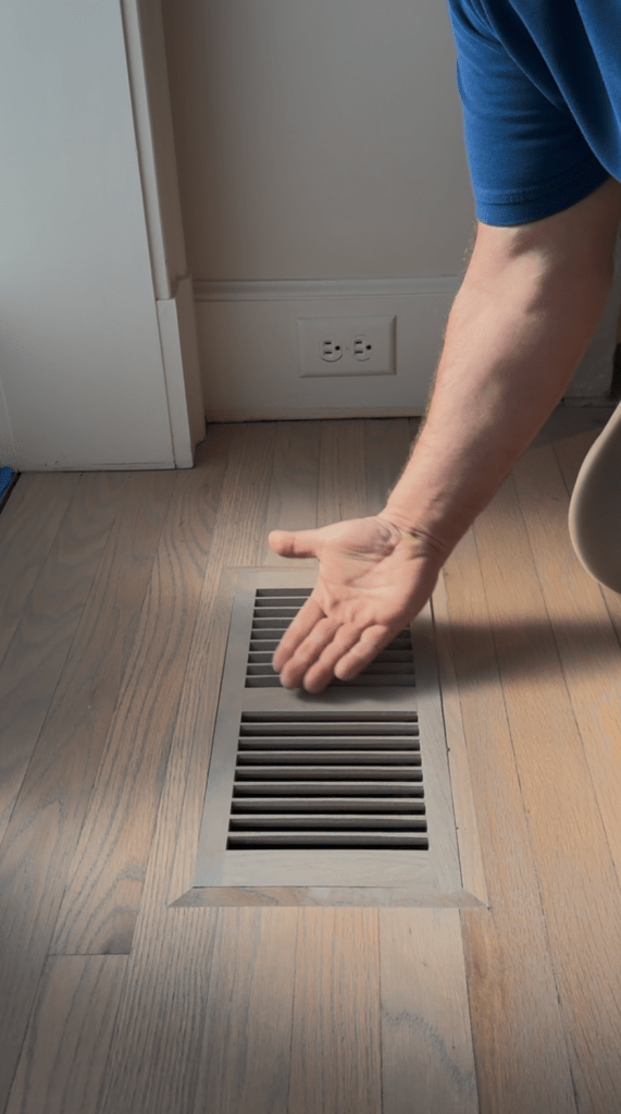 Final fit check on installed custom slat-profile wood floor vent finished with Rubio Monocoat Linen, Buckhead residence.