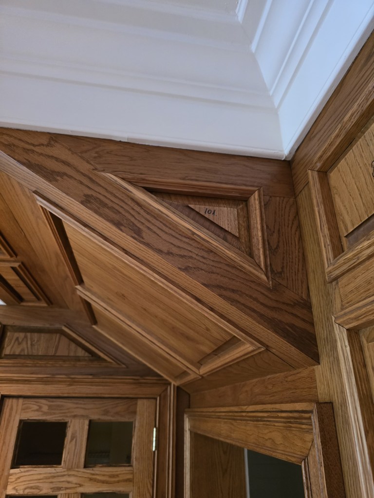 Original orange-toned oak paneling before refinishing — Buckhead great room, Classy Flooring ATL project