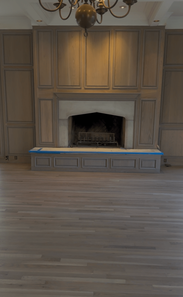 Finished white oak floor and oak panels refinished with Rubio Monocoat Oil Plus 2C in Linen, shown facing the fireplace and refinished paneling in a Buckhead family room.