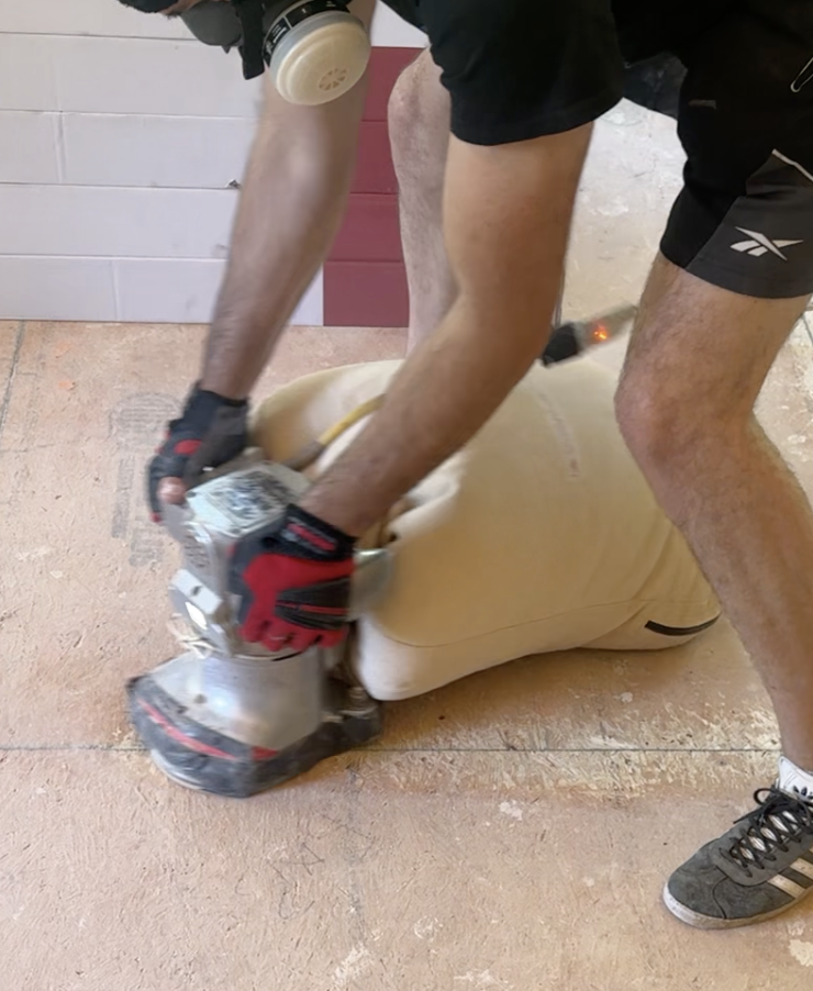 Classy Flooring ATL installer using an edge sander to feather the seams between plywood sheets during subfloor preparation in a Canton, GA home