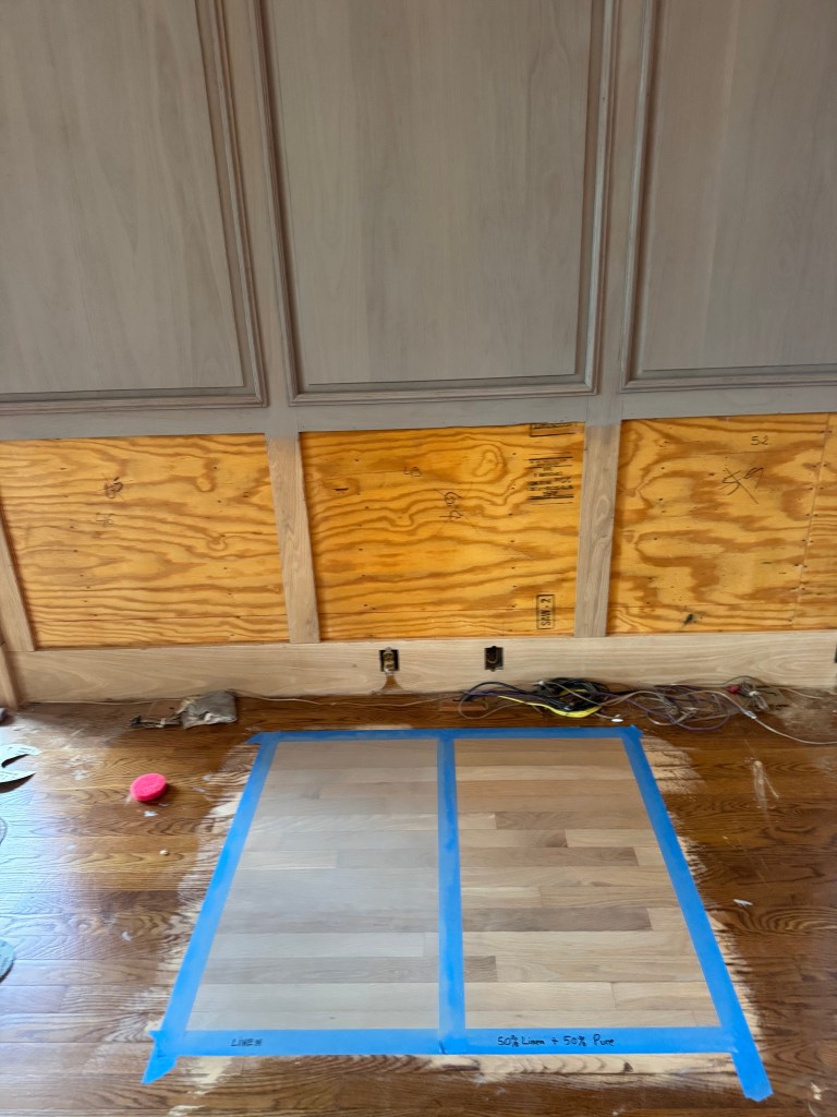 Rubio Monocoat second-round sample panels — Linen and 50/50 Linen and Pure blend — on sanded white oak in front of refinished oak paneling in a Buckhead home.