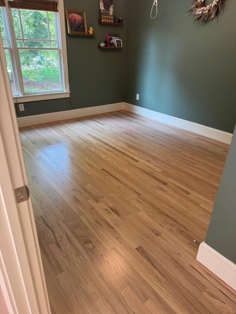 Finished red oak floor in a former carpeted room after new installation and refinishing in Atlanta, new boards matching the existing floors in the rest of the house