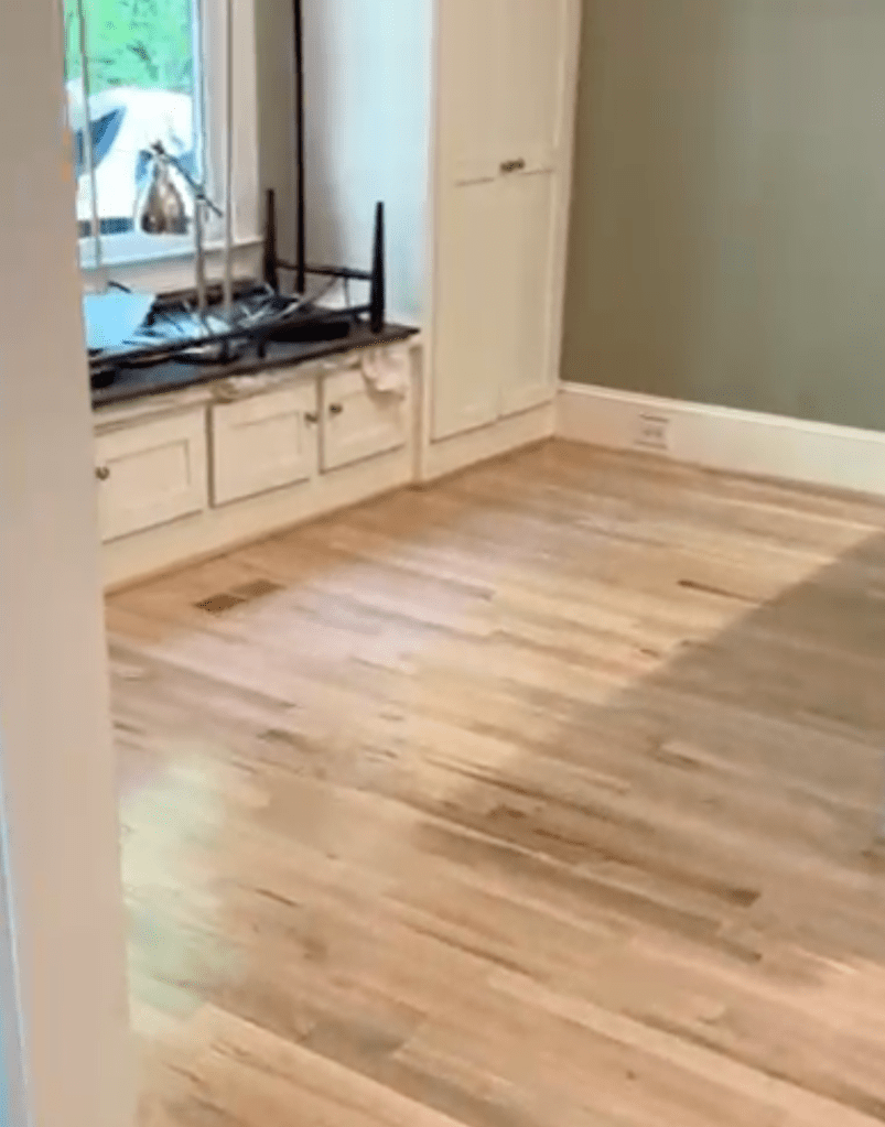 New flush-mount wood vent installed in a sanded red oak floor during refinishing in Atlanta, sitting level with the surrounding bare boards