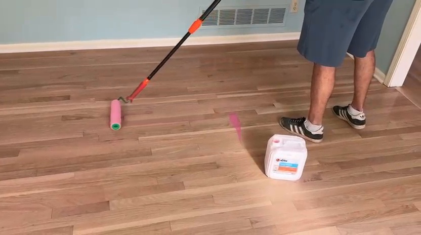Roller loaded with tinted LOBA 2K Duo on a white oak floor in Dunwoody GA
