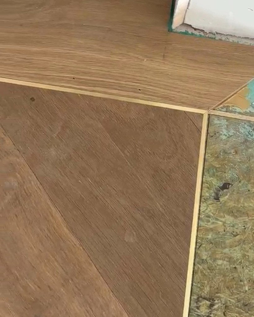 Mitered corner of solid brass inlay installed around the European white oak herringbone field, with the catwalk border area prepared for installation in Woodstock, Georgia.