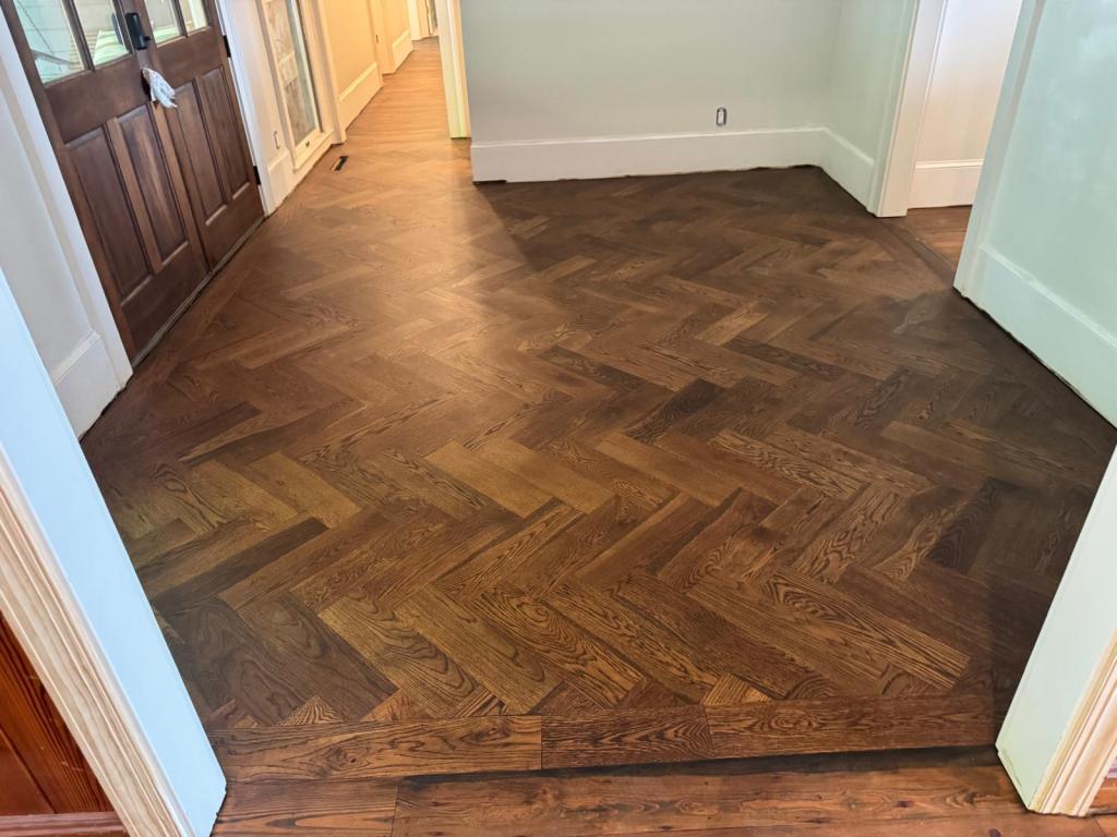 White oak herringbone in DuraSeal Espresso meeting reclaimed heart pine in DuraSeal Jacobean directly with no transition strip, Big Canoe, Georgia