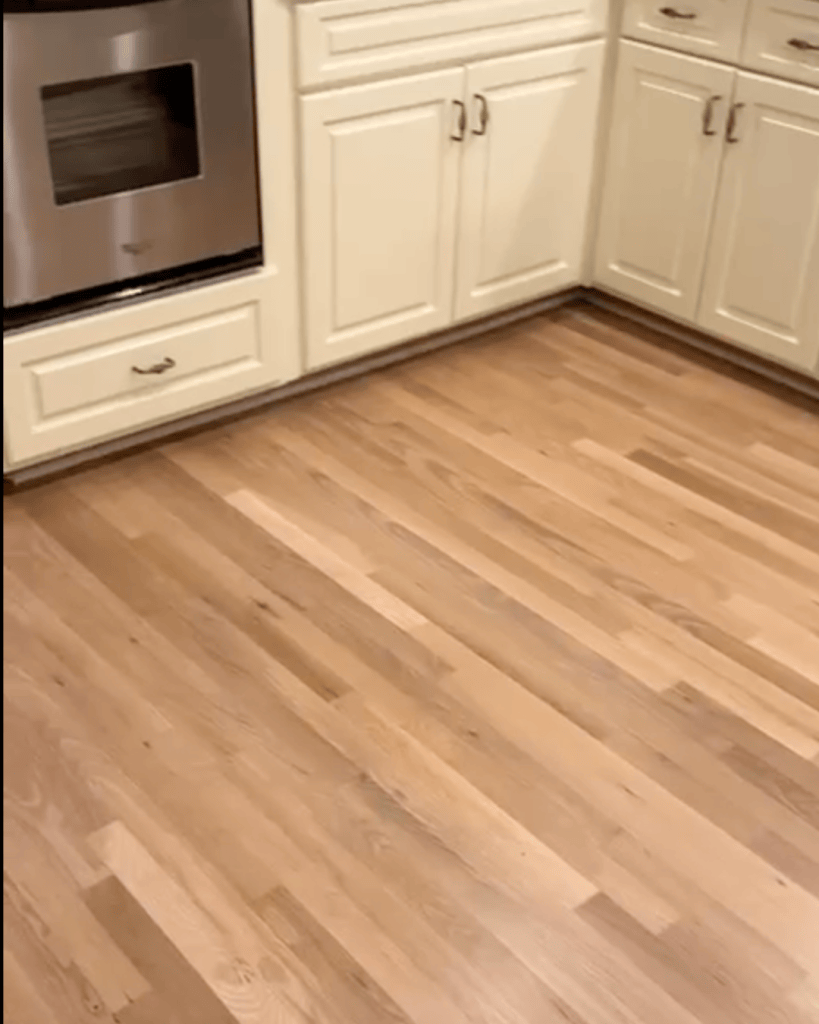 Refinished white oak floor in the kitchen running to the cabinet base, Dunwoody GA