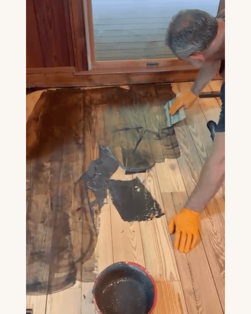 Working the second coat of AquaSeal PAK-Stop filler into wide gaps in the reclaimed heart pine floor, Big Canoe, Georgia