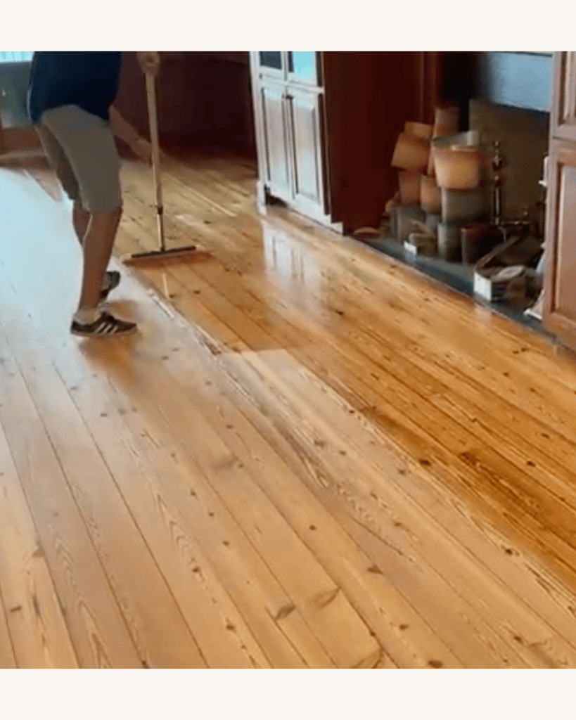 Applying the dewaxed shellac wash coat to the sanded reclaimed heart pine floor before staining, Big Canoe, Georgia