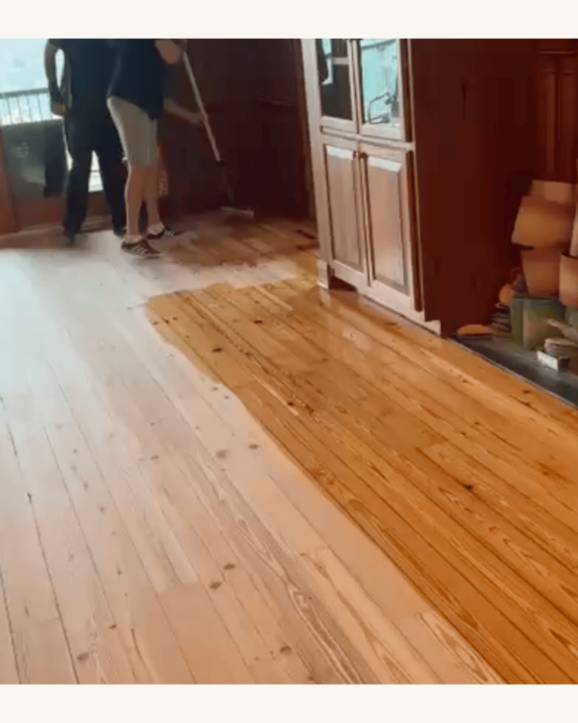 Classy Flooring ATL crew applying a Zinsser SealCoat dewaxed shellac wash coat across the sanded reclaimed heart pine floor in Big Canoe, Georgia