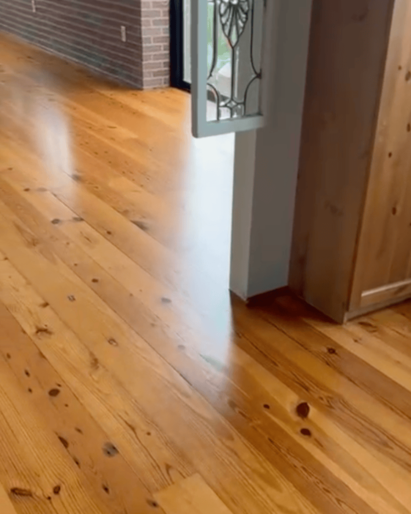 Refinished heart pine floor running past a doorway with daylight laid evenly across the boards, Roswell, Georgia