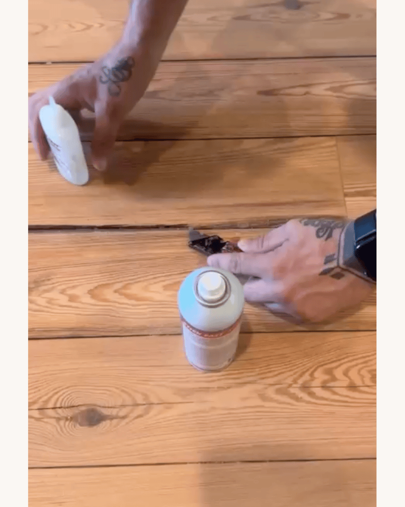 Classy Flooring ATL crew member applying Stick Fast cyanoacrylate glue and spray activator to a splinter repair in reclaimed heart pine flooring, Big Canoe, Georgia