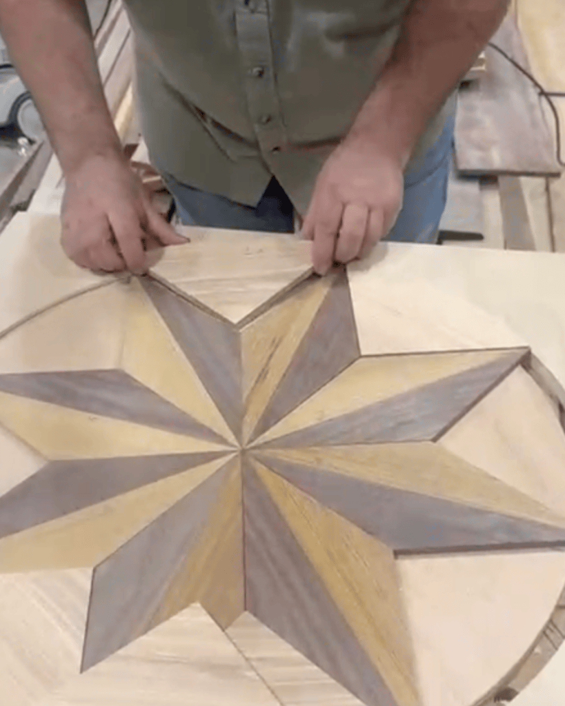 Claudiu Toma of Classy Flooring ATL fitting together the pieces of a star medallion he built during the NWFA Precision Patterns: Medallions course in St. Louis, Missouri